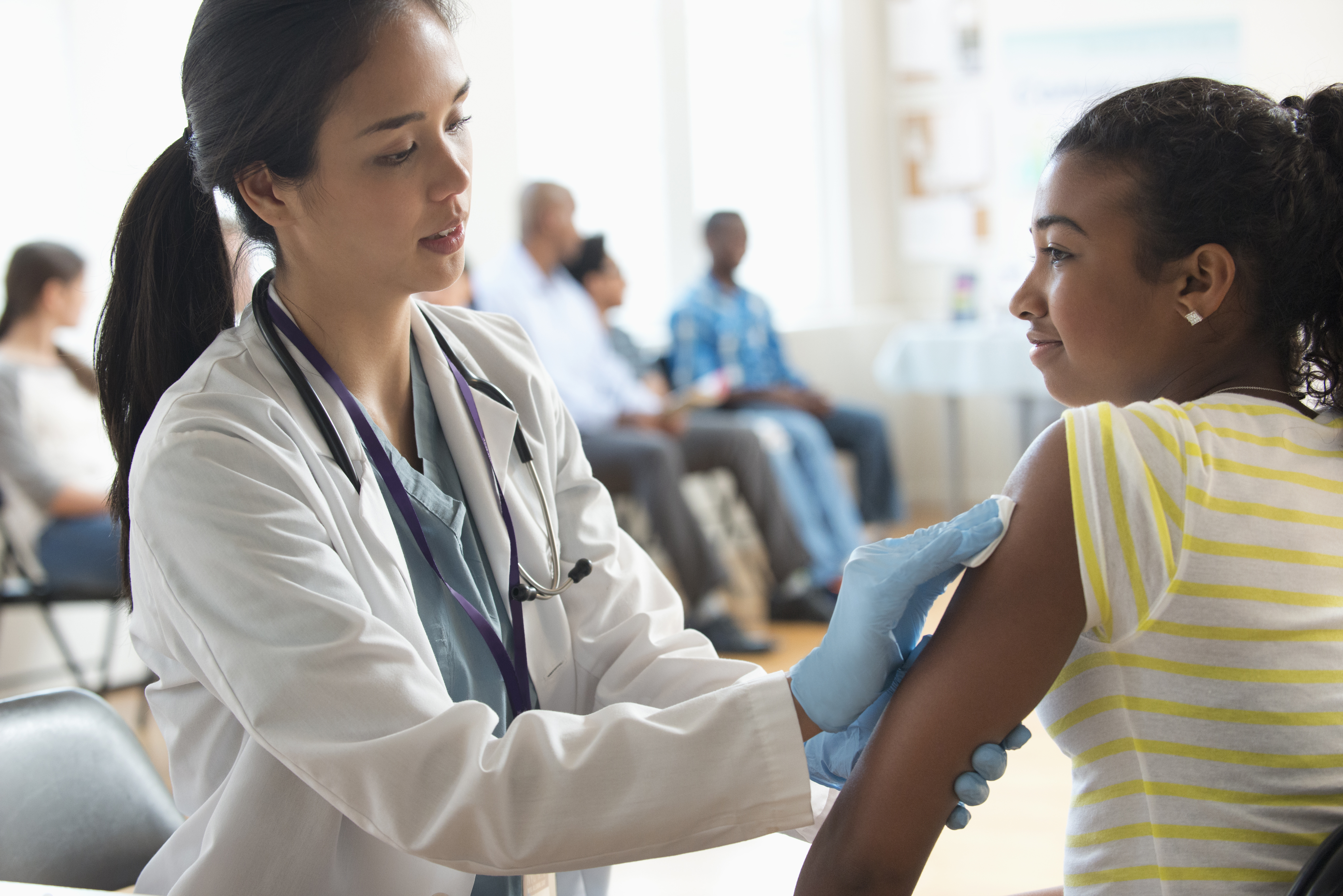 doctor vaccinating girl on left arm