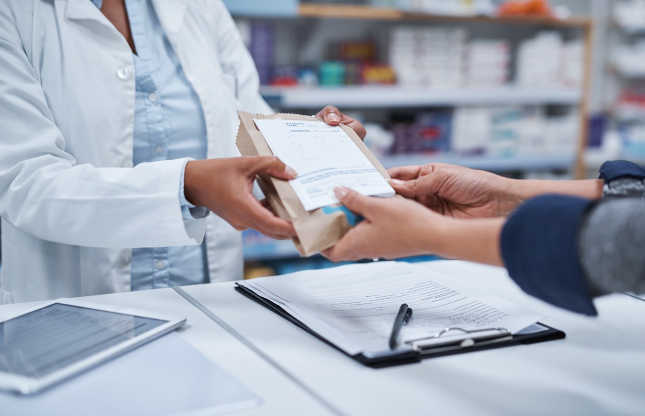 Pharmacist handing over medicine to user