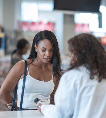 woman buying medication from pharmacist