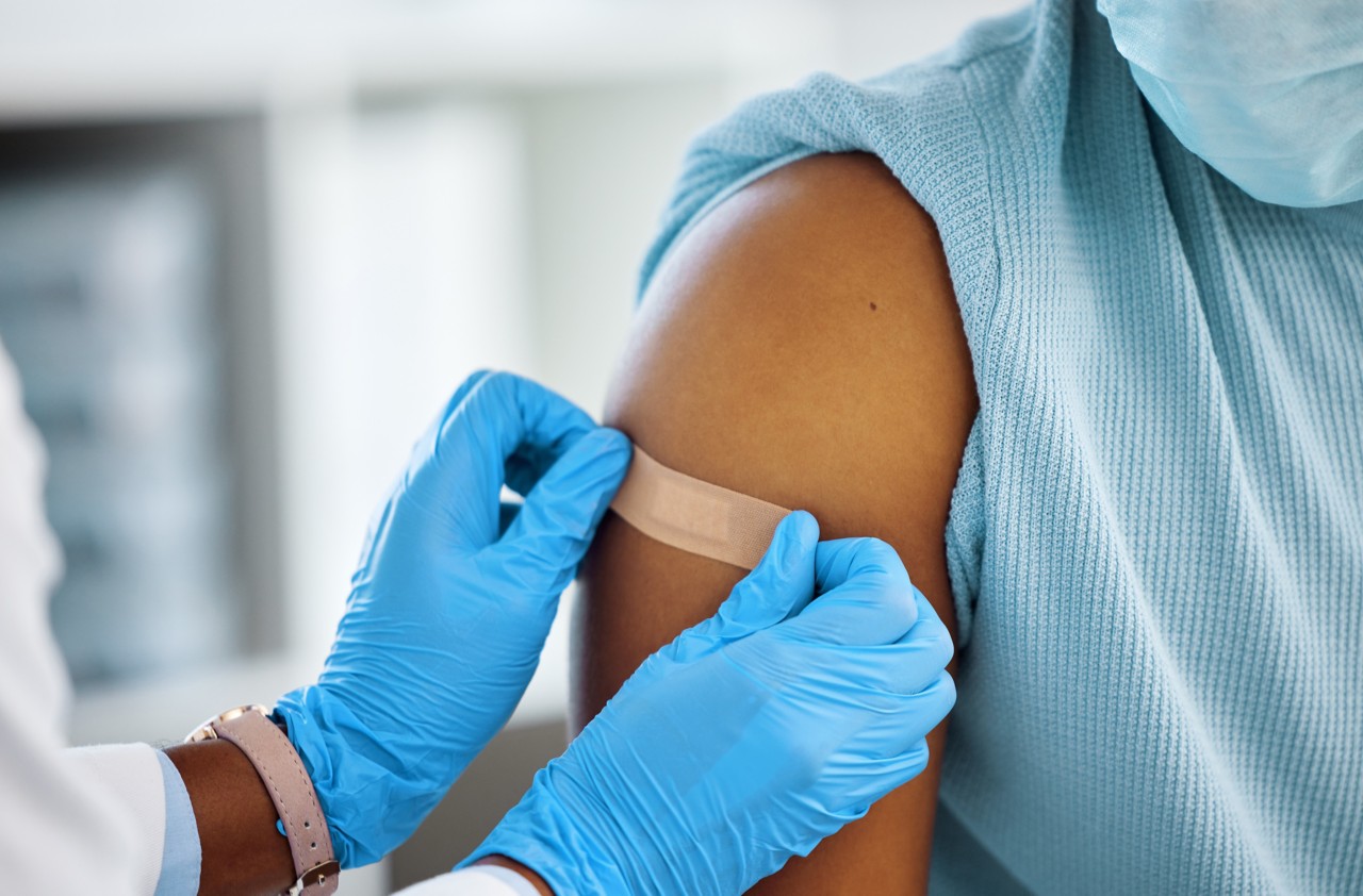 vaccinated user getting ban-aid on right arm