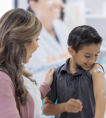 vaccinated boy child looking at band-aid